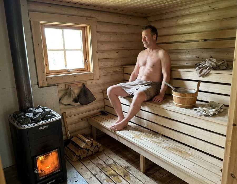 Interior of Finnish-style sauna with aspen benches and wood-burning stove